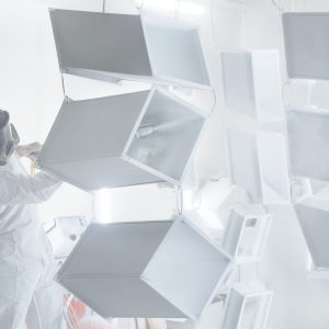 Metalwork workpiece factory paint air spray. Powder coating of metal products. Paint coating industry metal powder coating painting metal parts. Coveralls worker with spray gun painting steel products